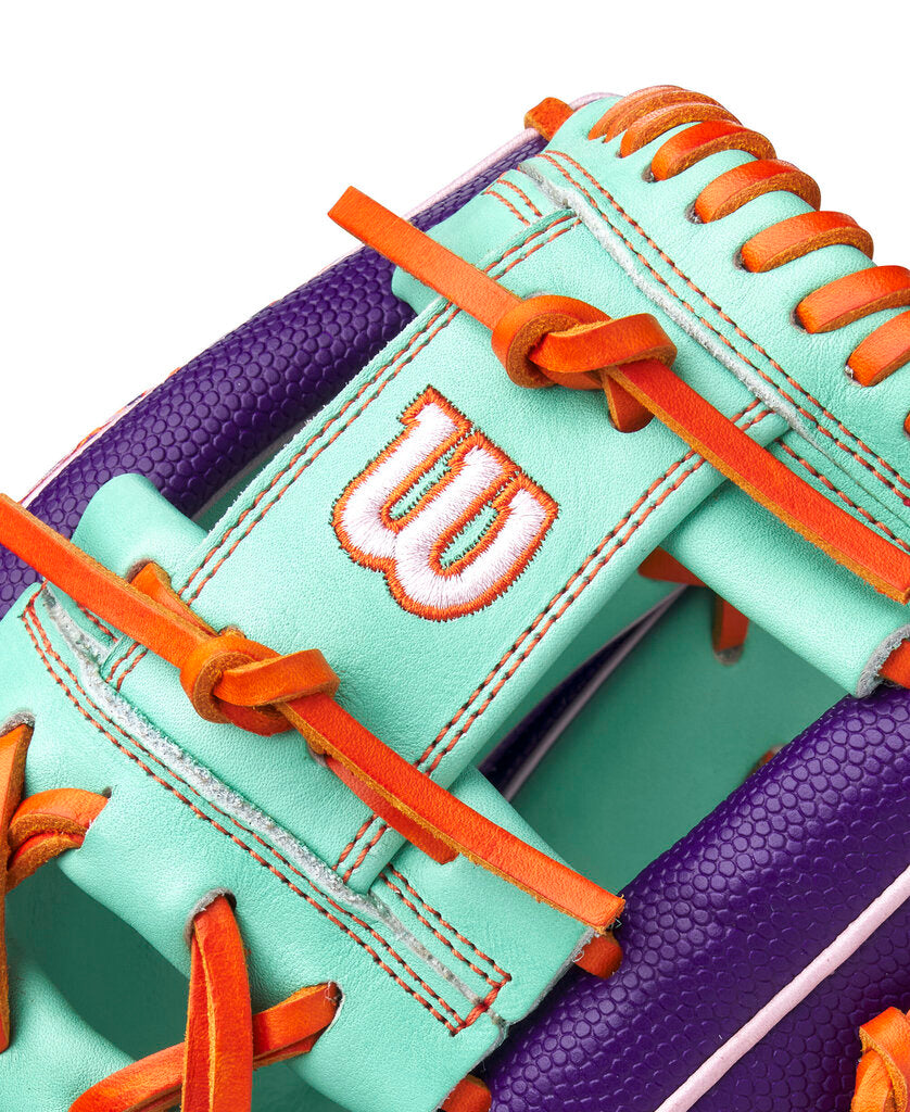 Baseball glove close-up of seafoam wrist strap with orange laces and Wilson logo patch
