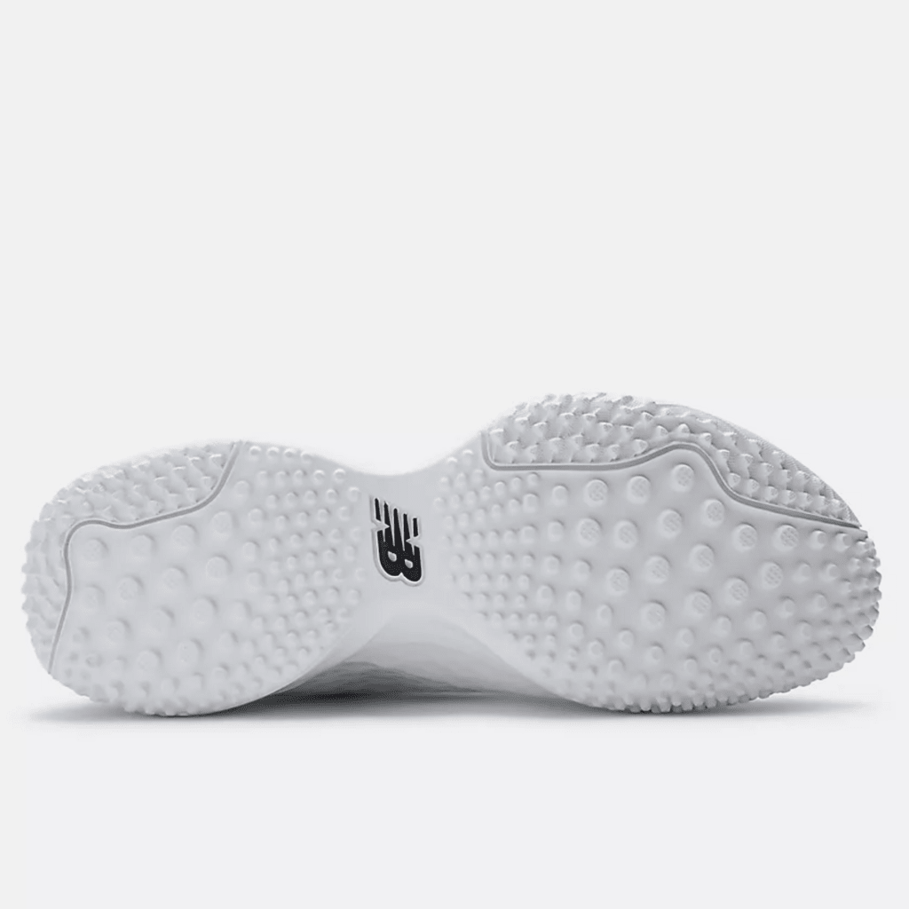 White turf shoe outsole with round studs and black New Balance logo