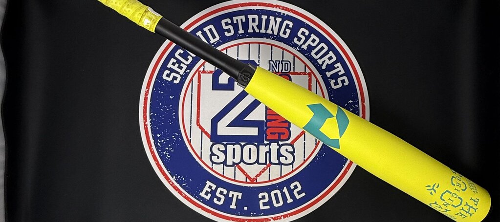 Yellow and teal baseball bat with black grip, branded barrel text and graphics visible