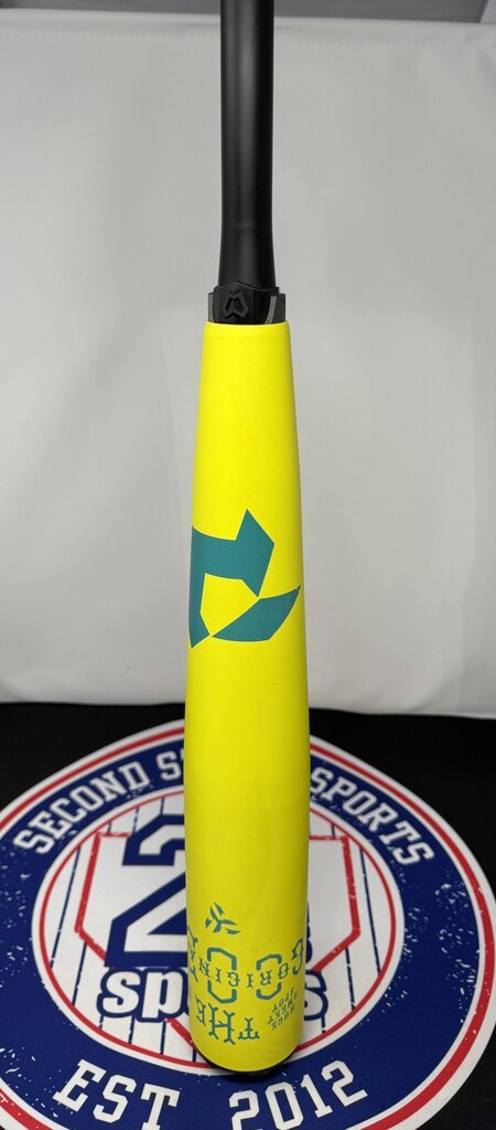 Yellow baseball bat upright with teal emblem and small printed numbers near the grip