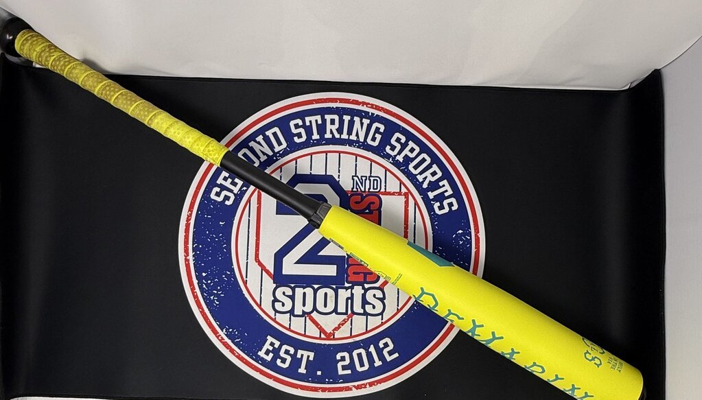 Yellow baseball bat with teal logo on barrel and black handle, laid across logo background