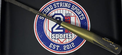 Used baseball bat with dark olive barrel and black grip, showing model markings