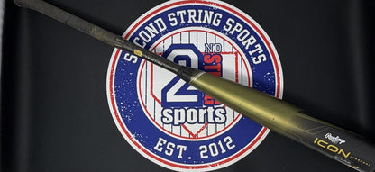 Used baseball bat with dark olive barrel, black grip, and handle-side markings