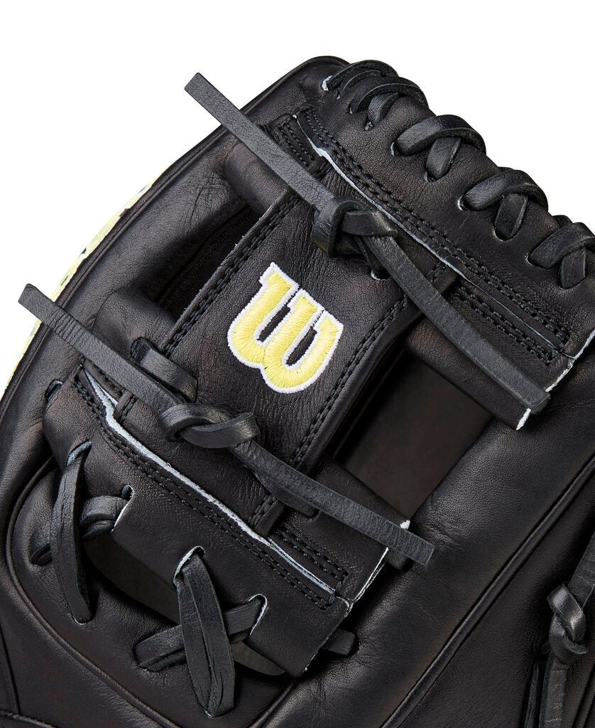 Black baseball glove close-up of the web with yellow Wilson “W” and thick laces