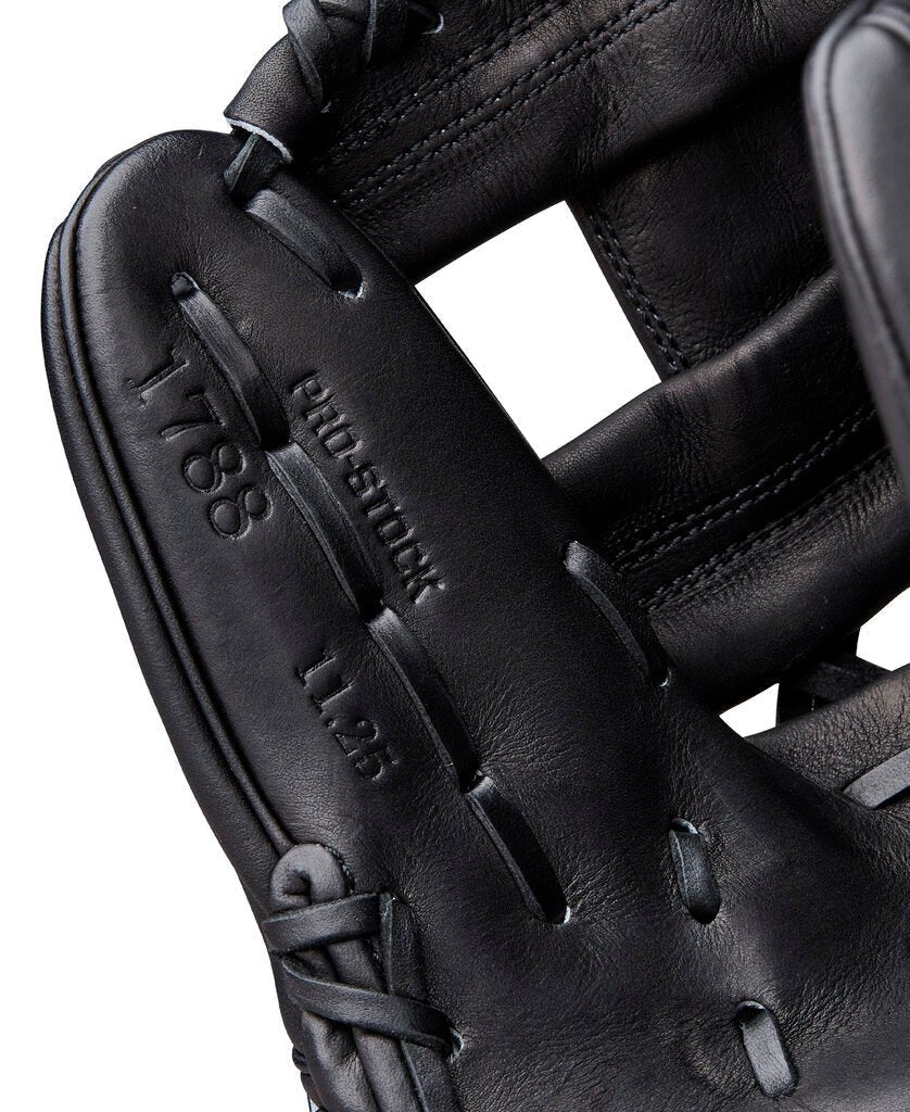 Close-up of black baseball glove finger stall and embossed “Wilson” lettering