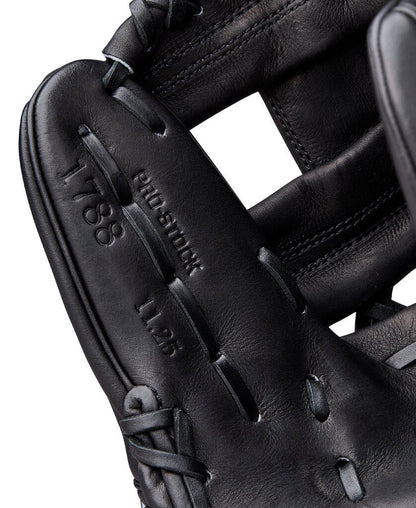 Close-up of black baseball glove finger stall and embossed “Wilson” lettering